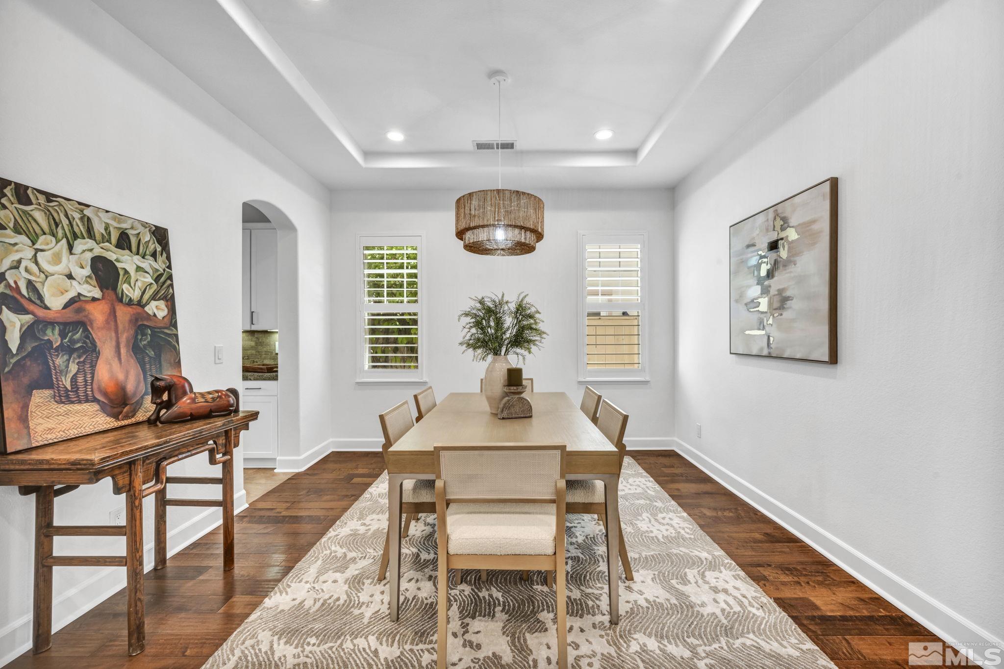 7665 Stone Bluff Way Reno, NV 89523 - Photo 6 of 40 a dining room with wooden floor and a chandelier