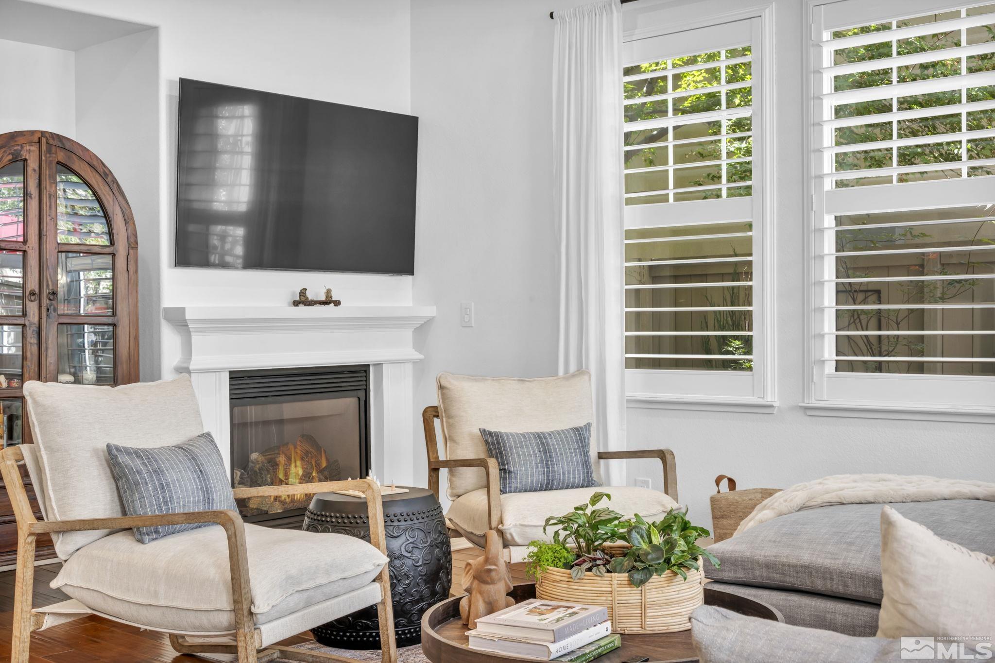 7665 Stone Bluff Way Reno, NV 89523 - Photo 10 of 40 a living room with furniture a flat screen tv and a fireplace
