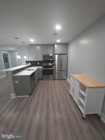 a large kitchen with a center island and stainless steel appliances