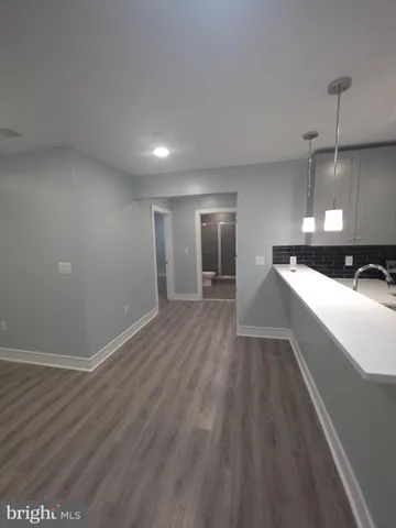 a kitchen with stainless steel appliances granite countertop a sink a stove a refrigerator and island with wooden floor