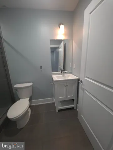 a bathroom with a toilet a sink and mirror