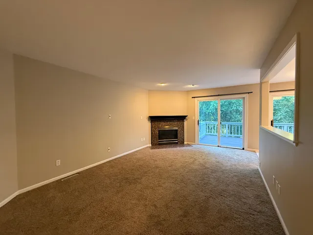 an empty room with fireplace and a window