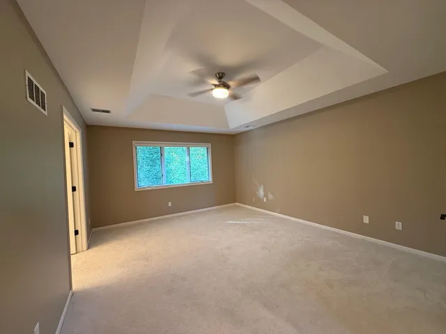an empty room with a window and a ceiling fan