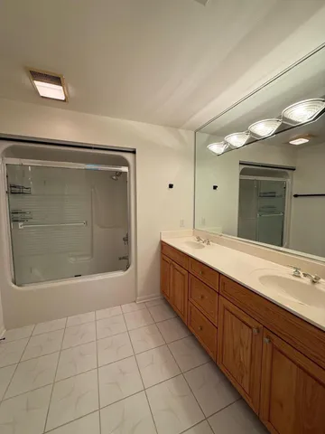 a bathroom with a sink a mirror and a shower