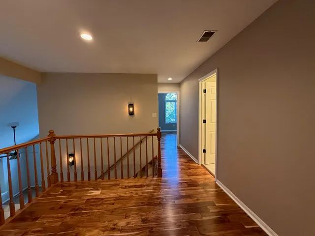 a view of a hallway with wooden floor