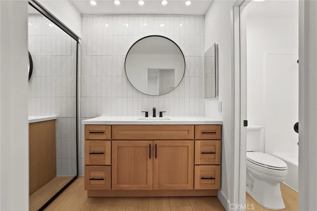 a spacious bathroom with a toilet a sink and a mirror