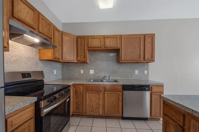 a kitchen with stainless steel appliances granite countertop a sink and a stove