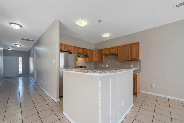 a kitchen with stainless steel appliances granite countertop a refrigerator a sink and a stove