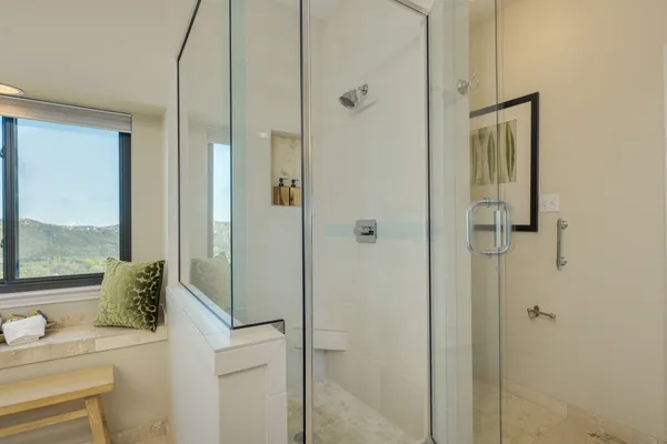 a bathroom with a granite countertop sink a mirror a toilet and a shower