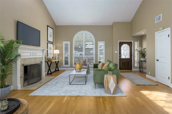 a living room with furniture a fireplace and a large window