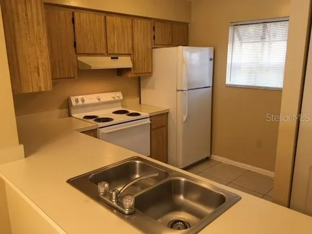 a kitchen with a refrigerator and a sink