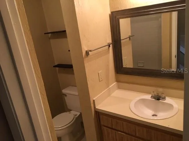 a bathroom with a sink toilet and mirror