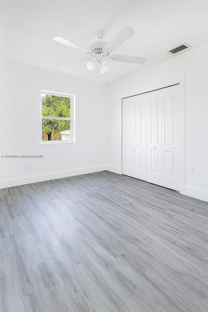 5825 Southwest 9th Terrace, Unit 2 West Miami, FL 33144 - Photo 5 of 11 an empty room with wooden floor and windows