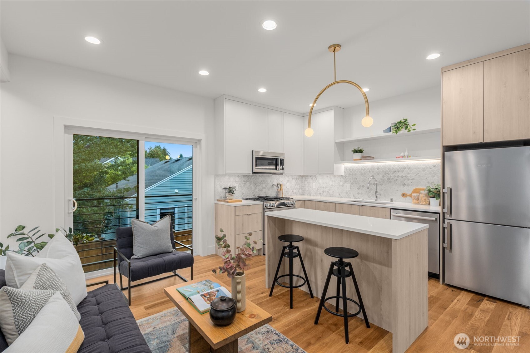 315 Northwest 86th Street, Unit B Seattle, WA 98117 - Photo 3 of 17 a kitchen with stainless steel appliances granite countertop a refrigerator a sink dishwasher a stove and a dining table with wooden floor