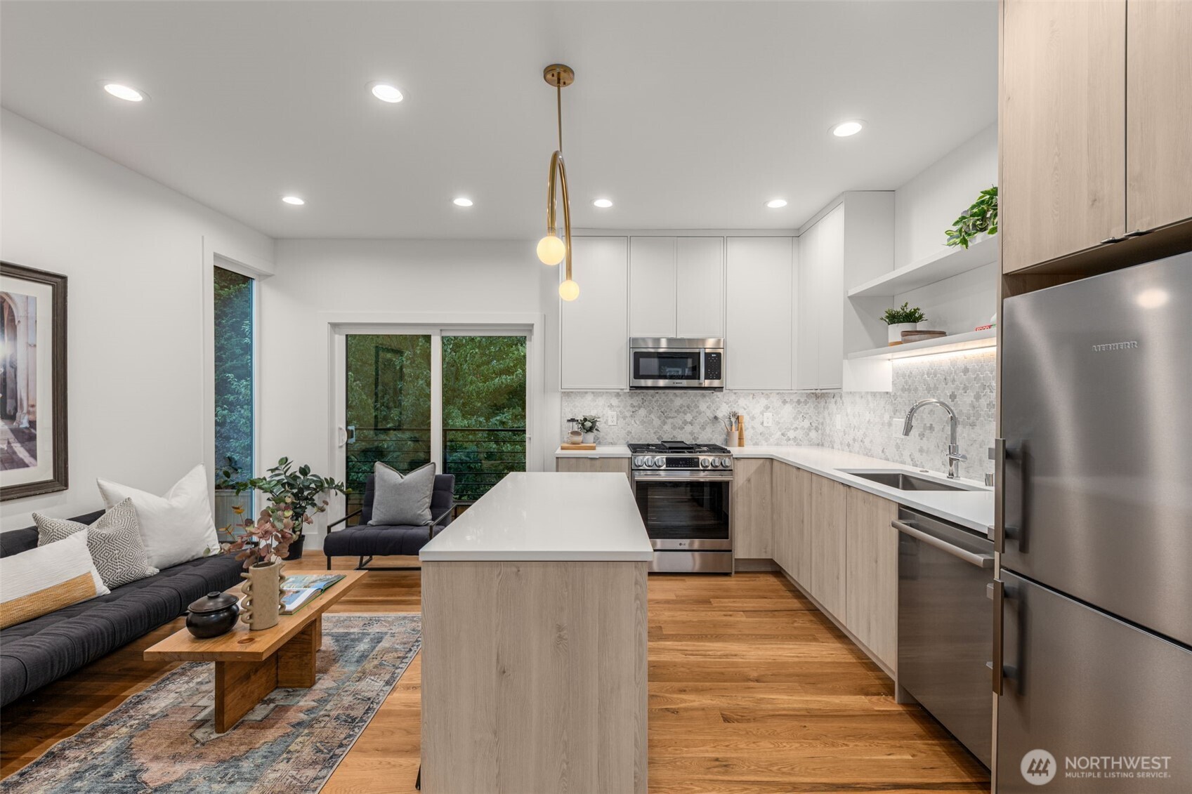 315 Northwest 86th Street, Unit B Seattle, WA 98117 - Photo 5 of 17 a kitchen with stainless steel appliances granite countertop a refrigerator a sink dishwasher a stove top oven a dining table and chairs with wooden floor