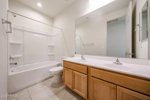 a bathroom with a double vanity sink toilet mirror and bathtub