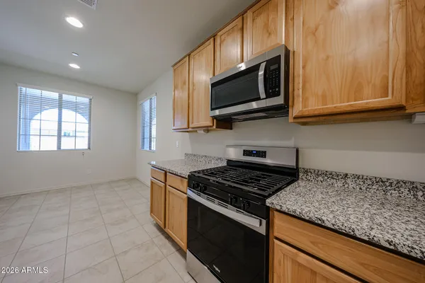 a kitchen with stainless steel appliances granite countertop white cabinets and a stove top oven