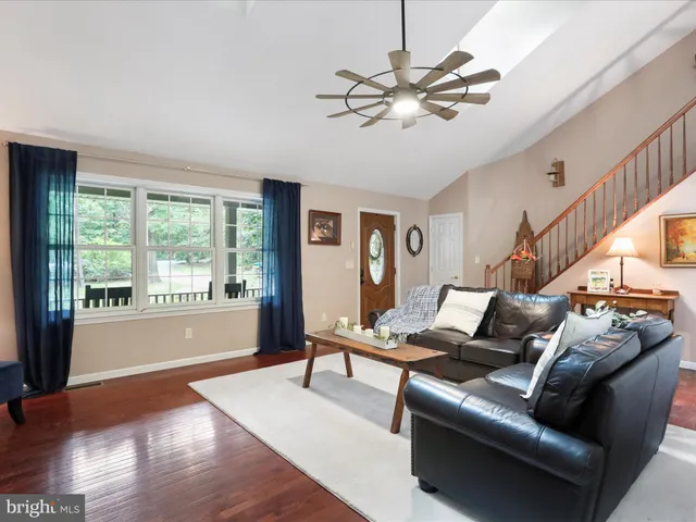 a living room with furniture a chandelier and a flat screen tv