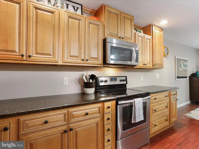 a kitchen with granite countertop a sink cabinets and wooden floor