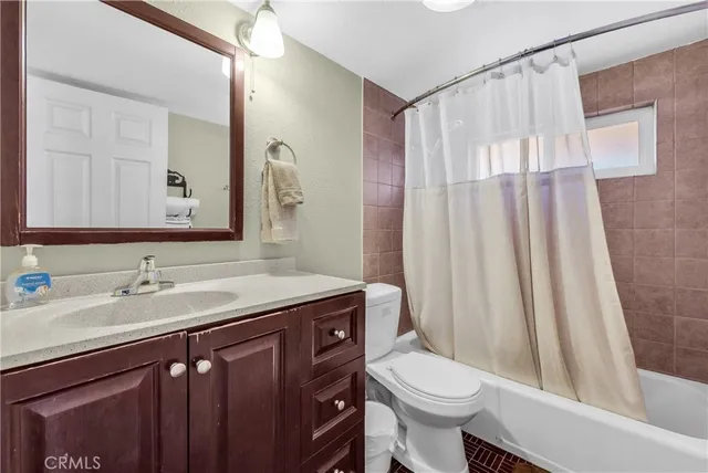 a bathroom with a sink a toilet a mirror a vanity and shower