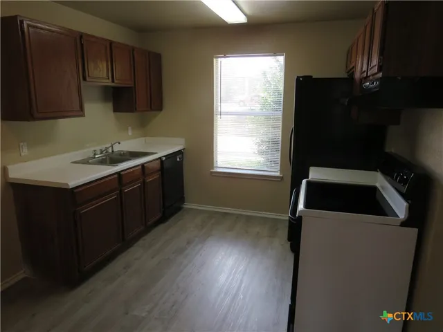 a kitchen with a sink a stove and cabinets