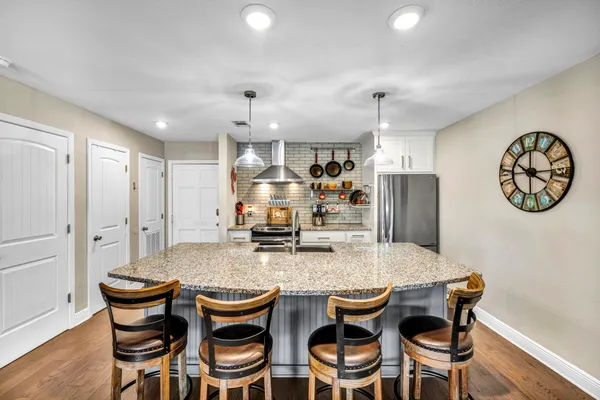 a kitchen with granite countertop kitchen island a counter space dining table and a couch
