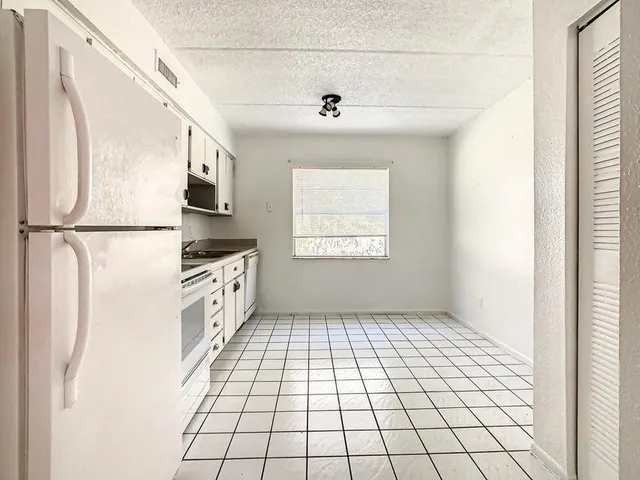 a kitchen with stainless steel appliances white cabinets and white appliances