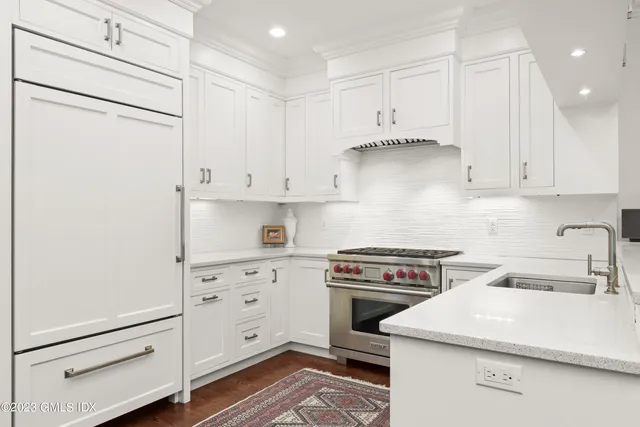 a kitchen with white cabinets and white appliances