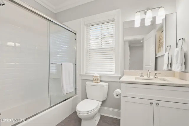 a bathroom with a sink toilet vanity and shower