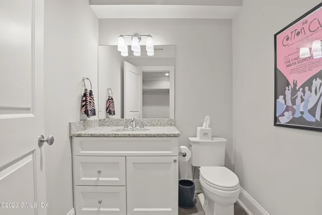 a bathroom with a granite countertop sink a toilet and a mirror