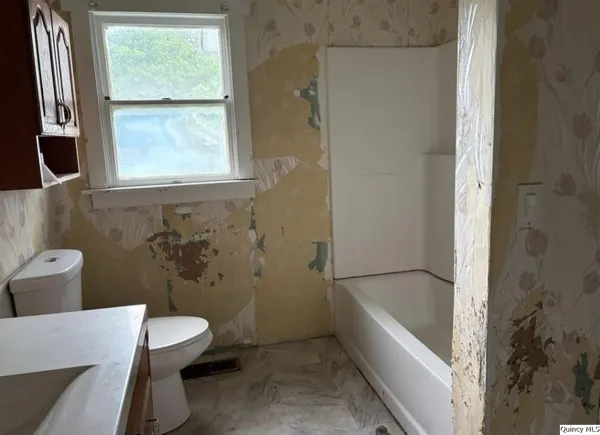 a bathroom with a sink a toilet a tub and shower