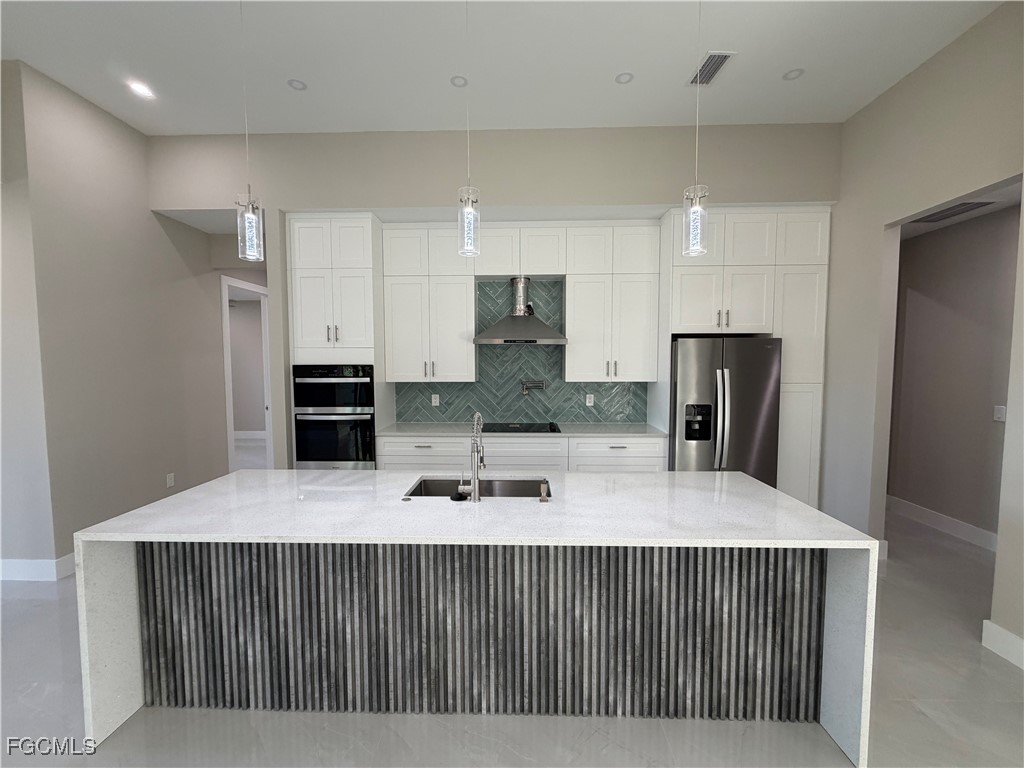 7968 3rd Terrace Lehigh Acres, FL 33936 - Photo 14 of 18 a kitchen with kitchen island a counter top space cabinets and refrigerator