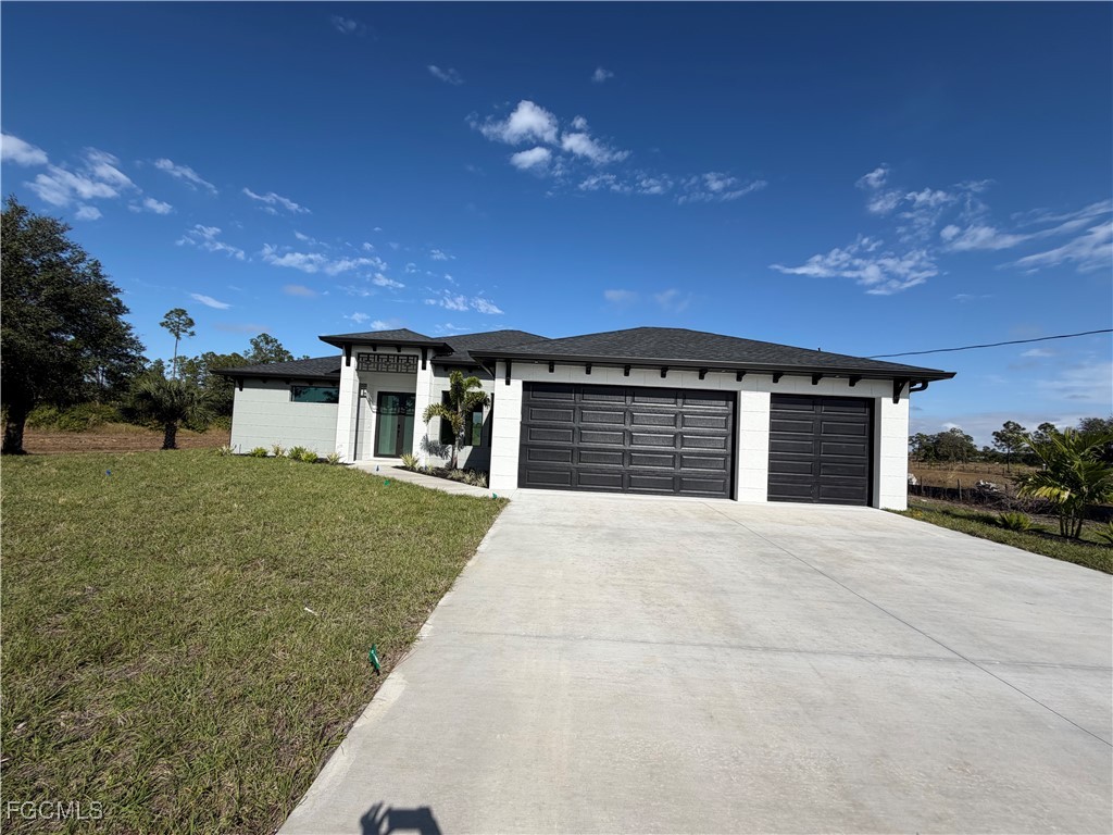7968 3rd Terrace Lehigh Acres, FL 33936 - Photo 4 of 18 a front view of a house with a yard and garage