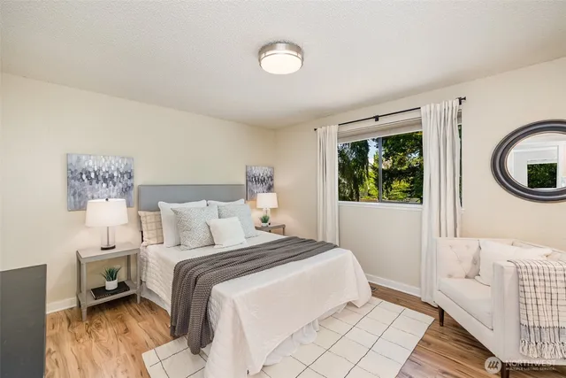 a bedroom with a bed a mirror and a window