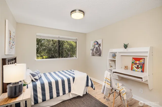 a bedroom with a bed and a painting on the wall