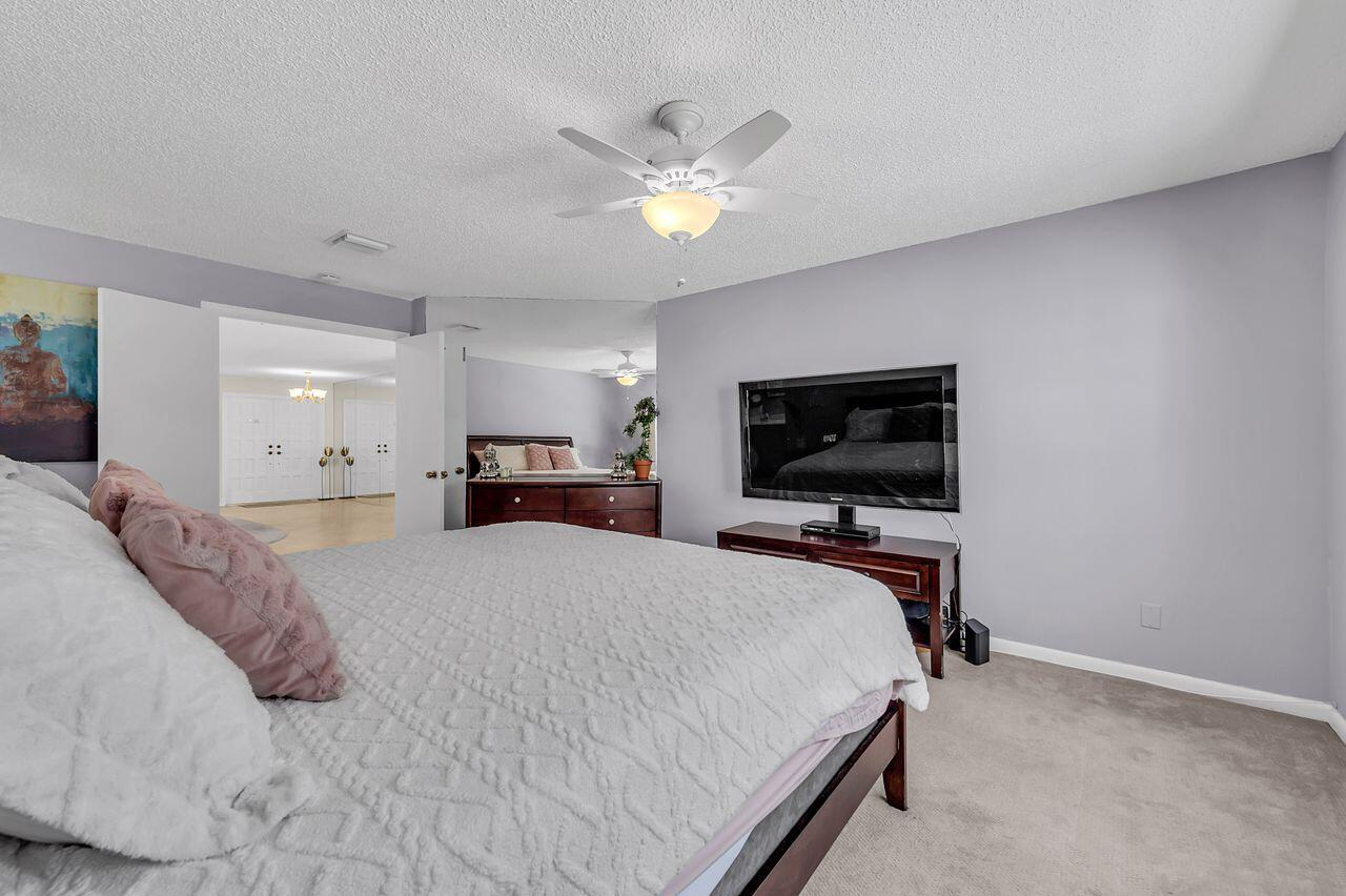 19699 Boca Greens Drive Boca Raton, FL 33498 - Photo 14 of 43 a bedroom with a bed and a flat screen tv