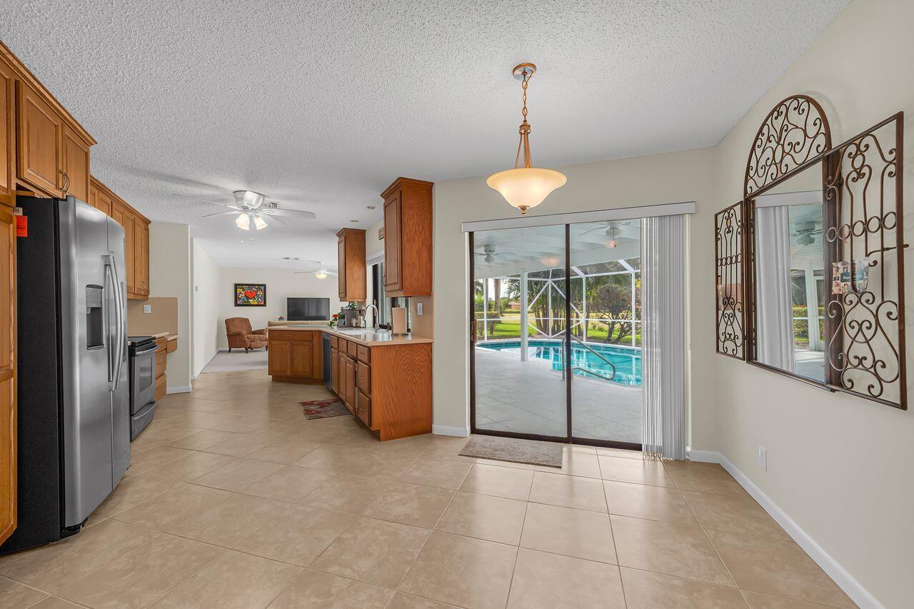 19699 Boca Greens Drive Boca Raton, FL 33498 - Photo 18 of 43 a view of a kitchen with furniture and a chandelier