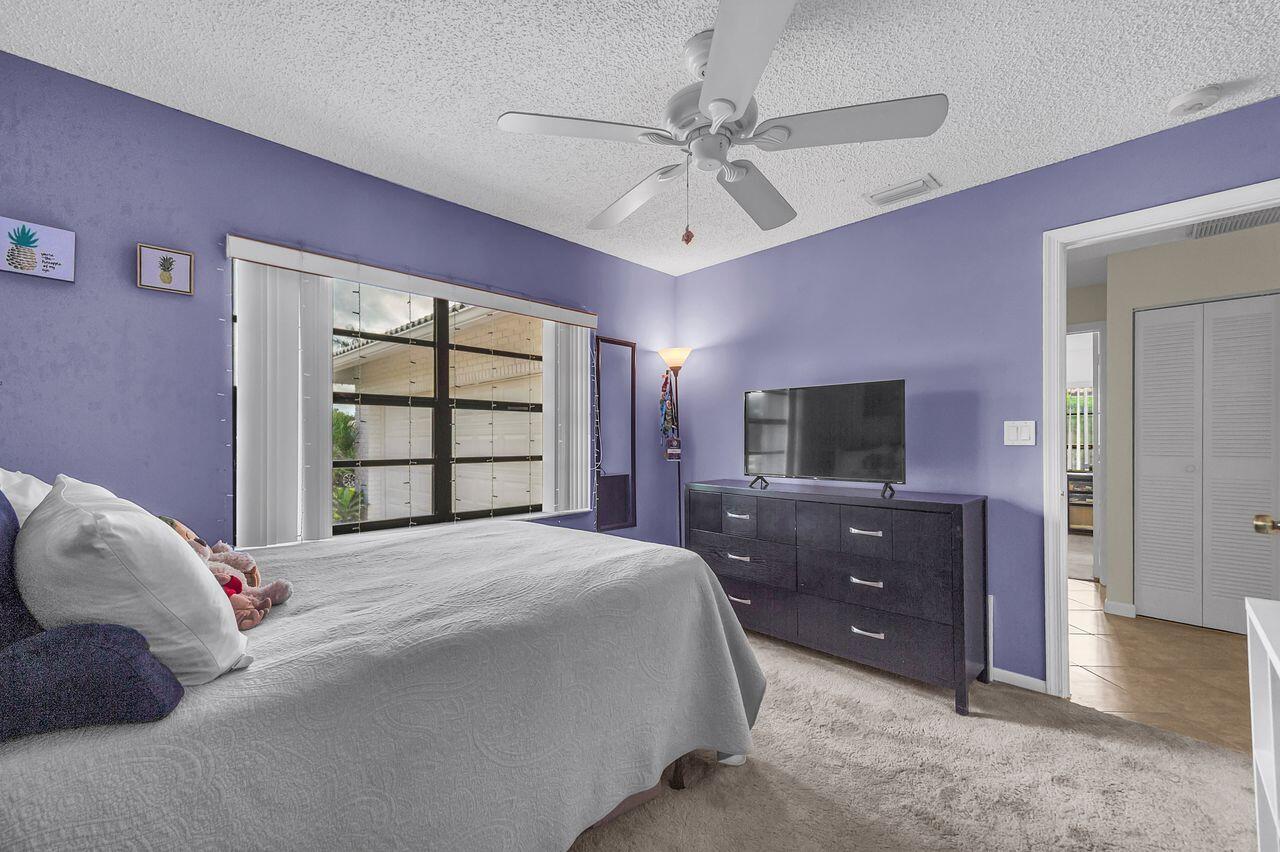 19699 Boca Greens Drive Boca Raton, FL 33498 - Photo 38 of 43 a bedroom with a bed and a flat screen tv