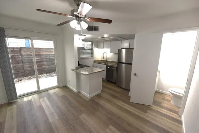 a view of a kitchen with a sink dishwasher and wooden floor