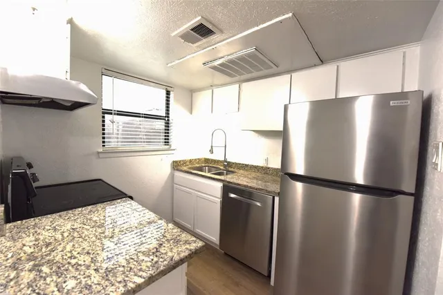 a kitchen with stainless steel appliances granite countertop a refrigerator and a stove