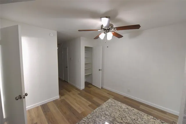 a view of a bedroom with a chandelier fan and a ceiling fan