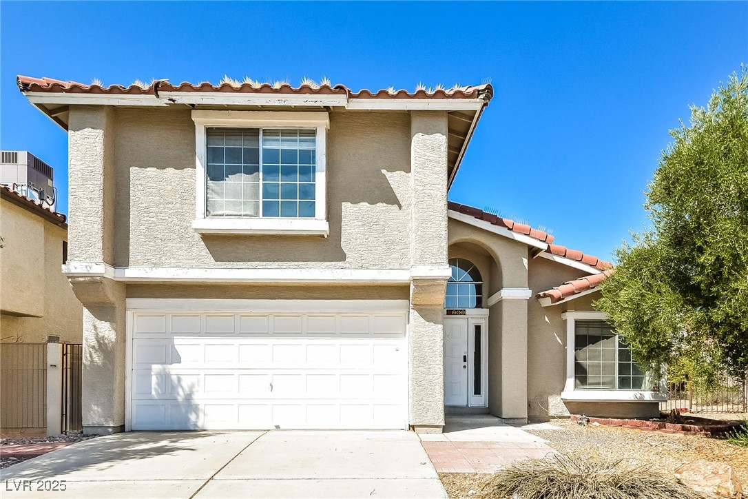 741 Round Table Drive Las Vegas, NV 89110 - Photo 1 of 22 View of front of house with an attached garage, a tile roof, stucco siding, and concrete driveway