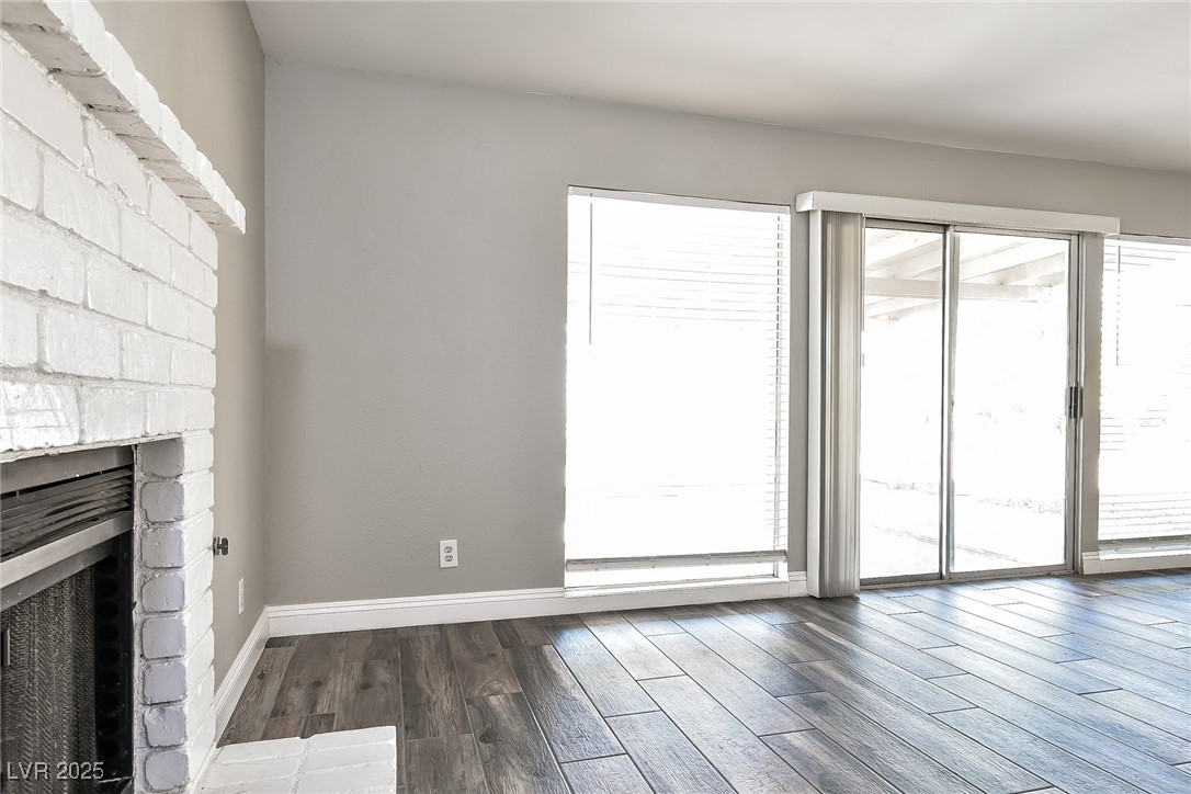 741 Round Table Drive Las Vegas, NV 89110 - Photo 9 of 22 Unfurnished living room with a stone fireplace and wood finished floors