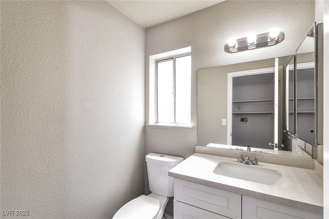 741 Round Table Drive Las Vegas, NV 89110 - Photo 18 of 22 Half bath featuring a textured wall and vanity