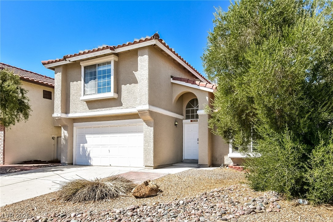 741 Round Table Drive Las Vegas, NV 89110 - Photo 3 of 22 View of front of house with an attached garage, stucco siding, driveway, and a tiled roof