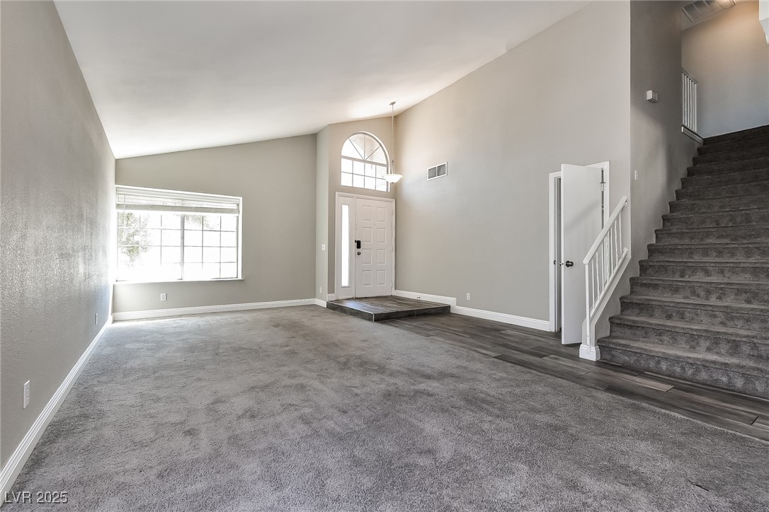 741 Round Table Drive Las Vegas, NV 89110 - Photo 5 of 22 Carpeted entryway featuring high vaulted ceiling and stairway