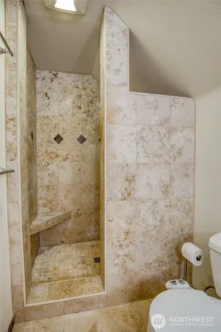 a bathroom with a toilet and a shower