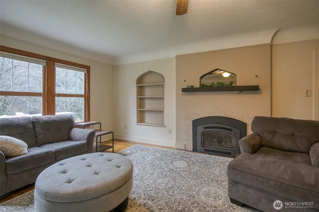a living room with furniture a fireplace and a large window