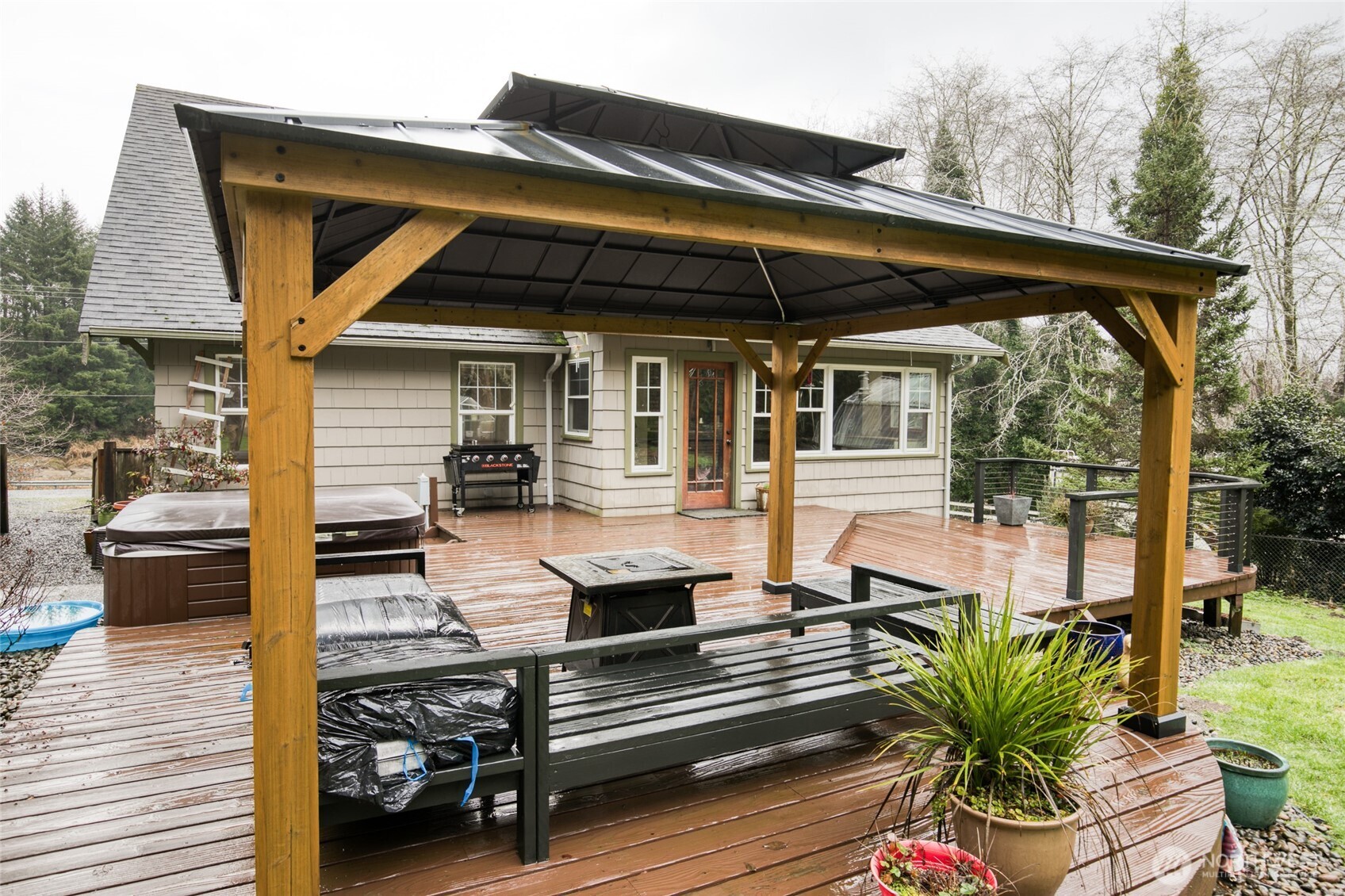 3321 Wishkah Road Aberdeen, WA 98520 - Photo 33 of 40 a view of a patio with table and chairs potted plants with wooden floor