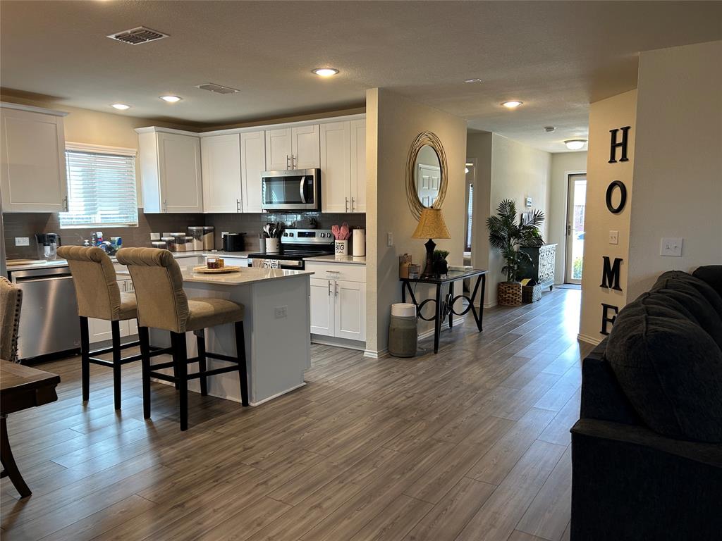 10109 Wyseby Road Crowley, TX 76036 - Photo 25 of 25 a kitchen with stainless steel appliances granite countertop a stove top oven a sink a dining table and chairs with wooden floor